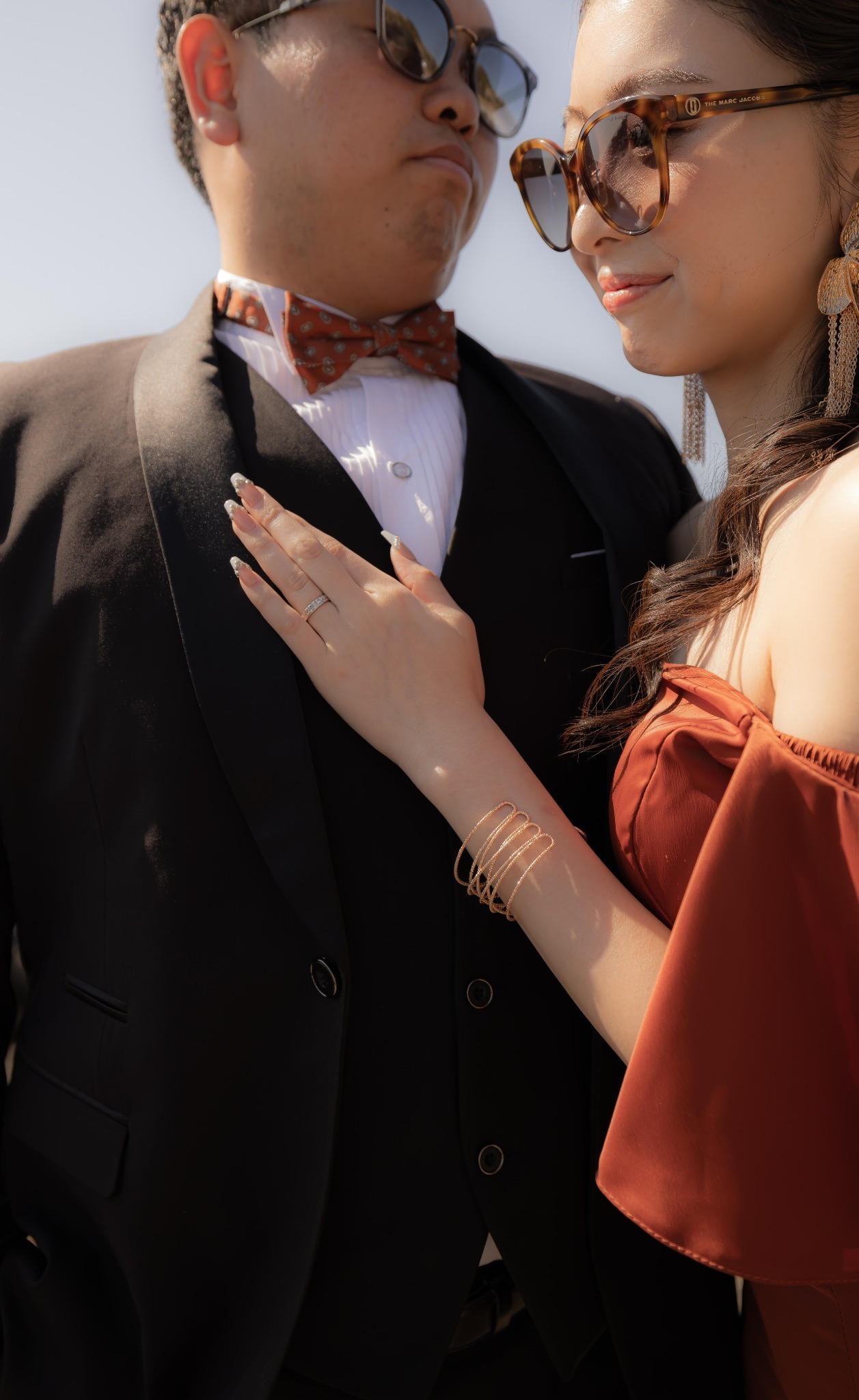 城ヶ島でオレンジドレスとブラックスーツ姿の新郎新婦を寄りで撮影した前撮り写真