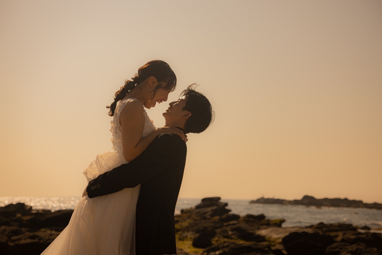 城ヶ島の夕景で新郎が新婦を抱き上げ見つめ合うウェディングフォト