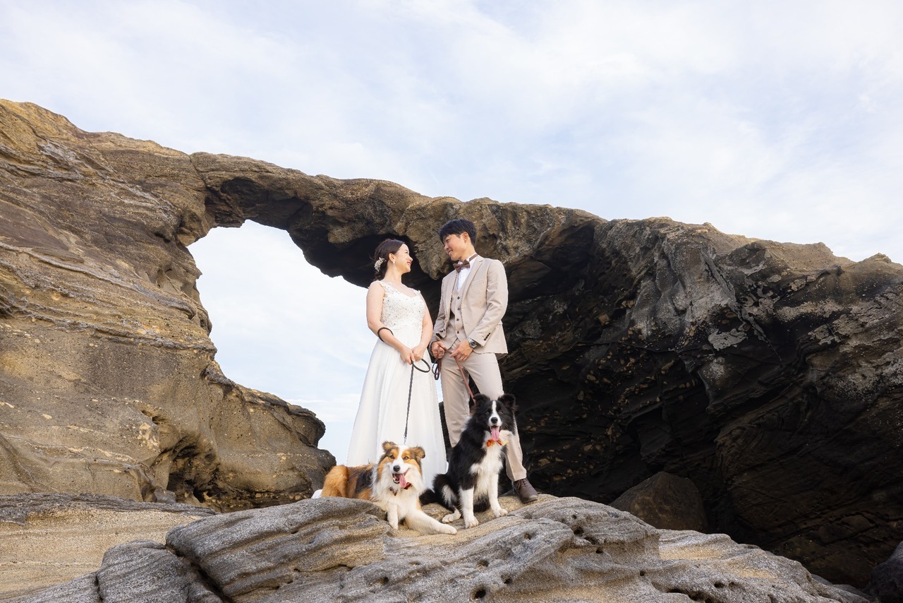 城ヶ島の岩場で愛犬2頭と一緒に撮影する新郎新婦のウェディングフォト