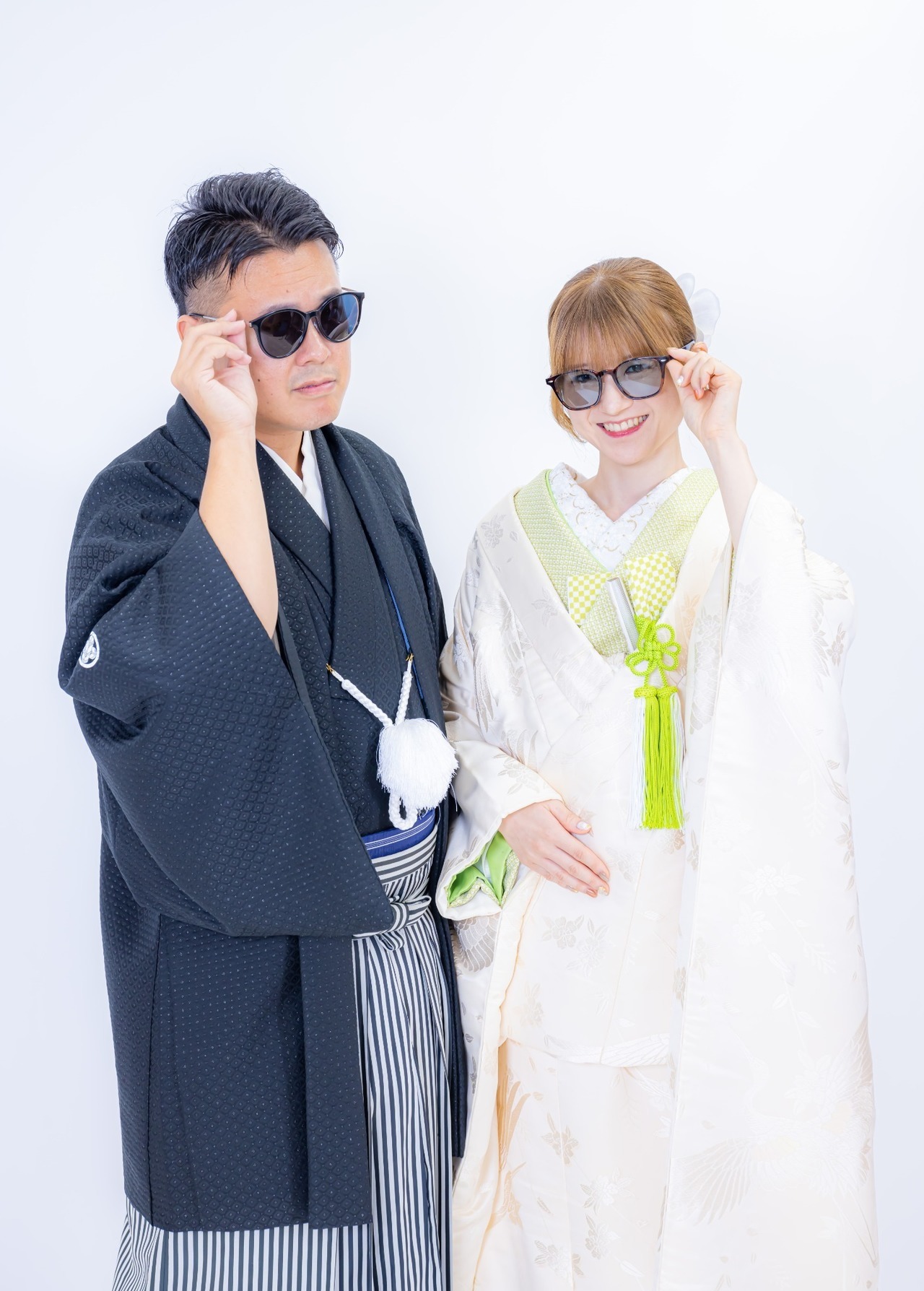 白を基調とした和装と黒紋付姿でサングラスをかける新郎新婦