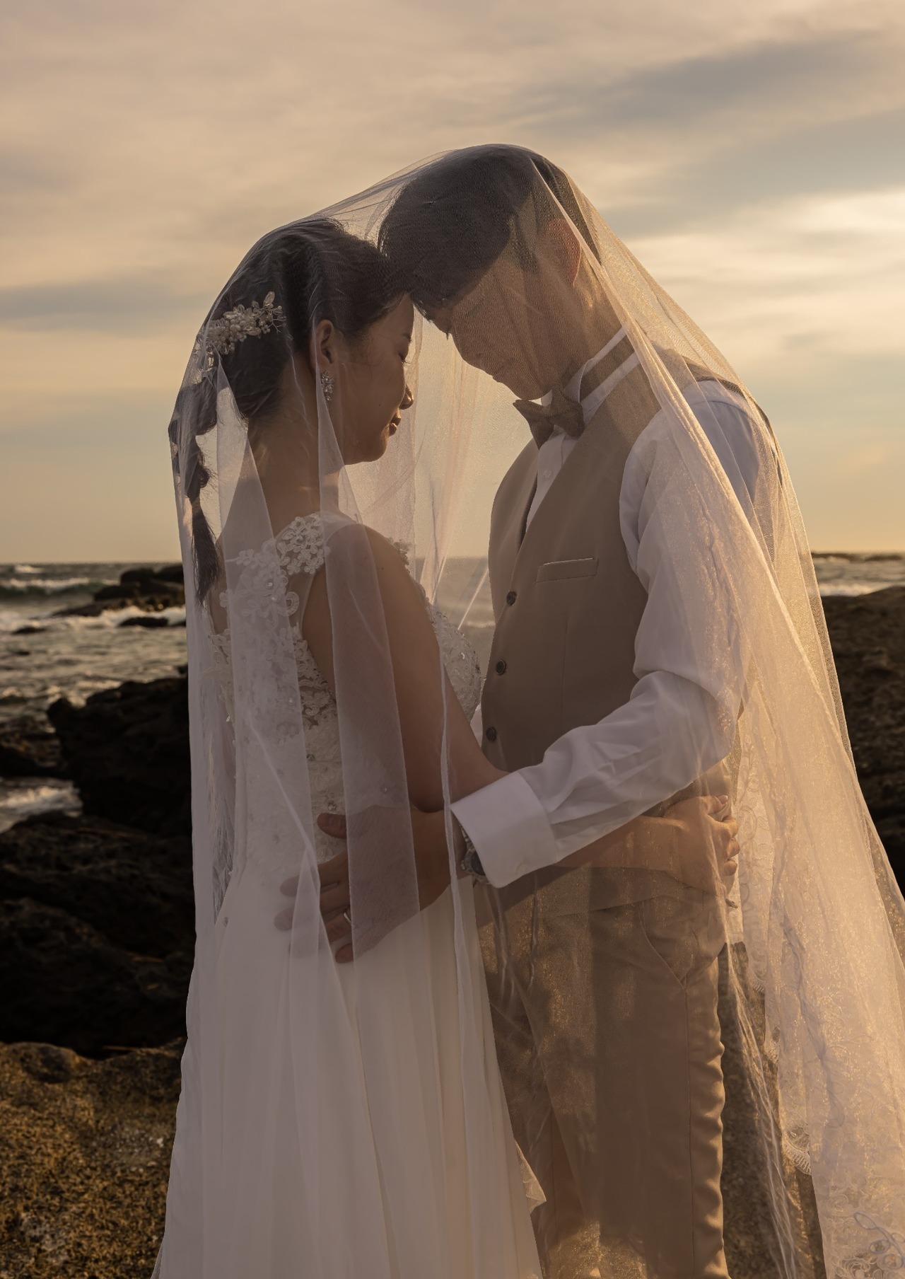 城ヶ島の夕景で手をつなぐ新郎新婦を暖かな光で撮影した前撮り写真