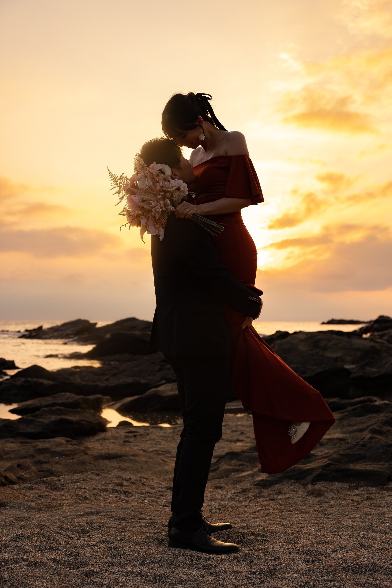 城ヶ島の夕陽を背景に新郎が新婦を抱き上げたシルエット風ウェディングフォト