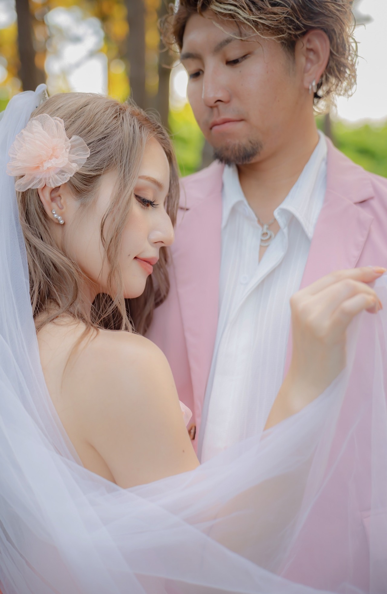 ベール越しに優しく微笑む新婦と新郎を写したやわらかい前撮りポートレート