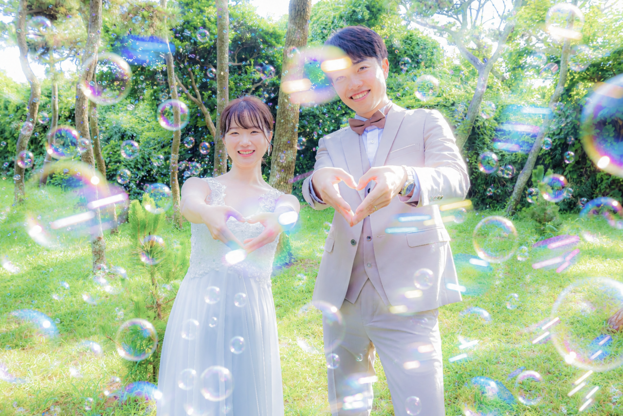 城ヶ島の緑の中でハートポーズとシャボン玉を楽しむ新郎新婦